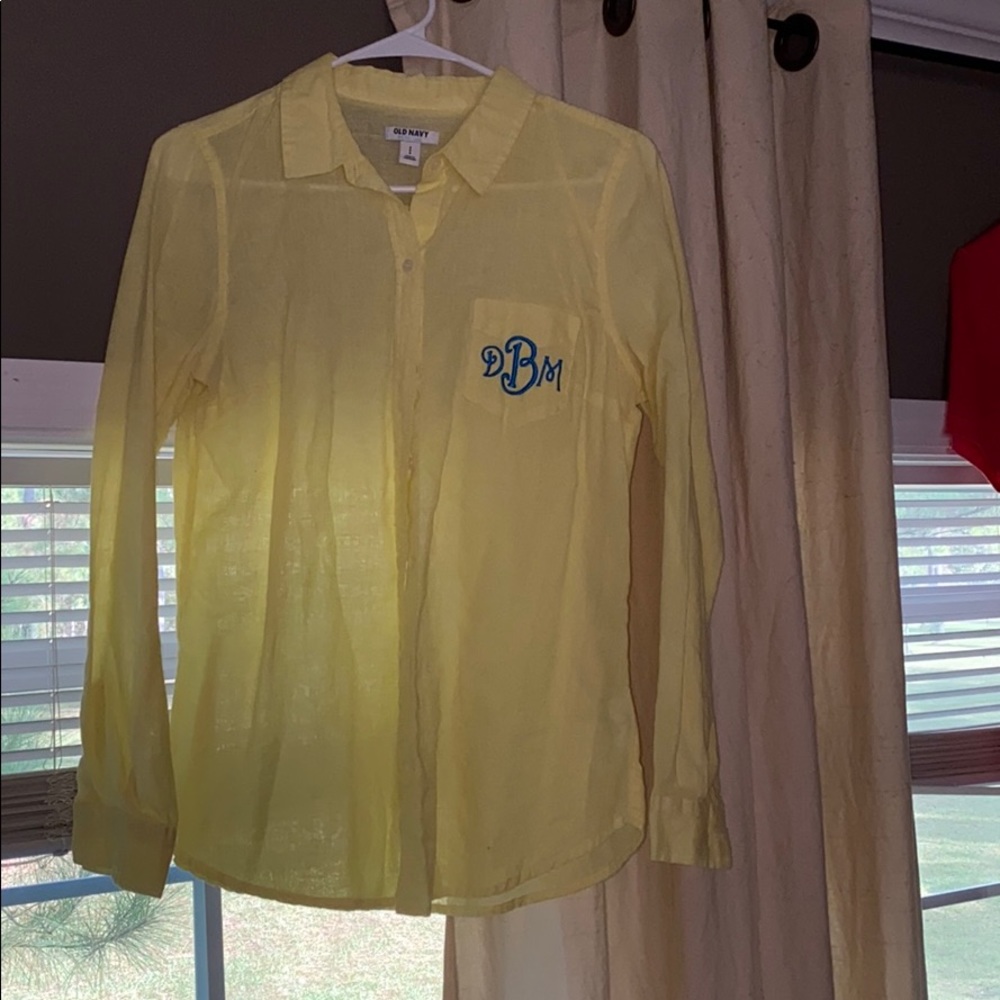 Yellow monogrammed button up shirt.